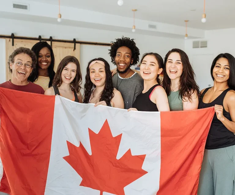 A joyful group of individuals proudly displaying the Canadian flag, celebrating their national pride together.