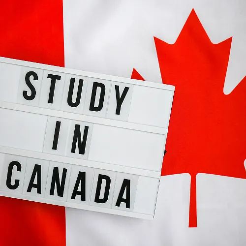 A sign "Study in Canada" laid over the Canadian flag, symbolizing academic pursuits in a Canadian setting.